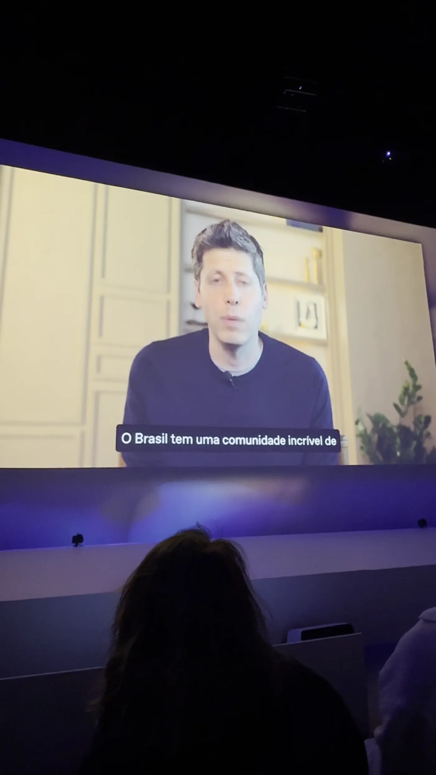 Sam Altman no telão: "O Brasil tem uma comunidade incrível de criadores. Estamos aqui para um compromisso de longo prazo."