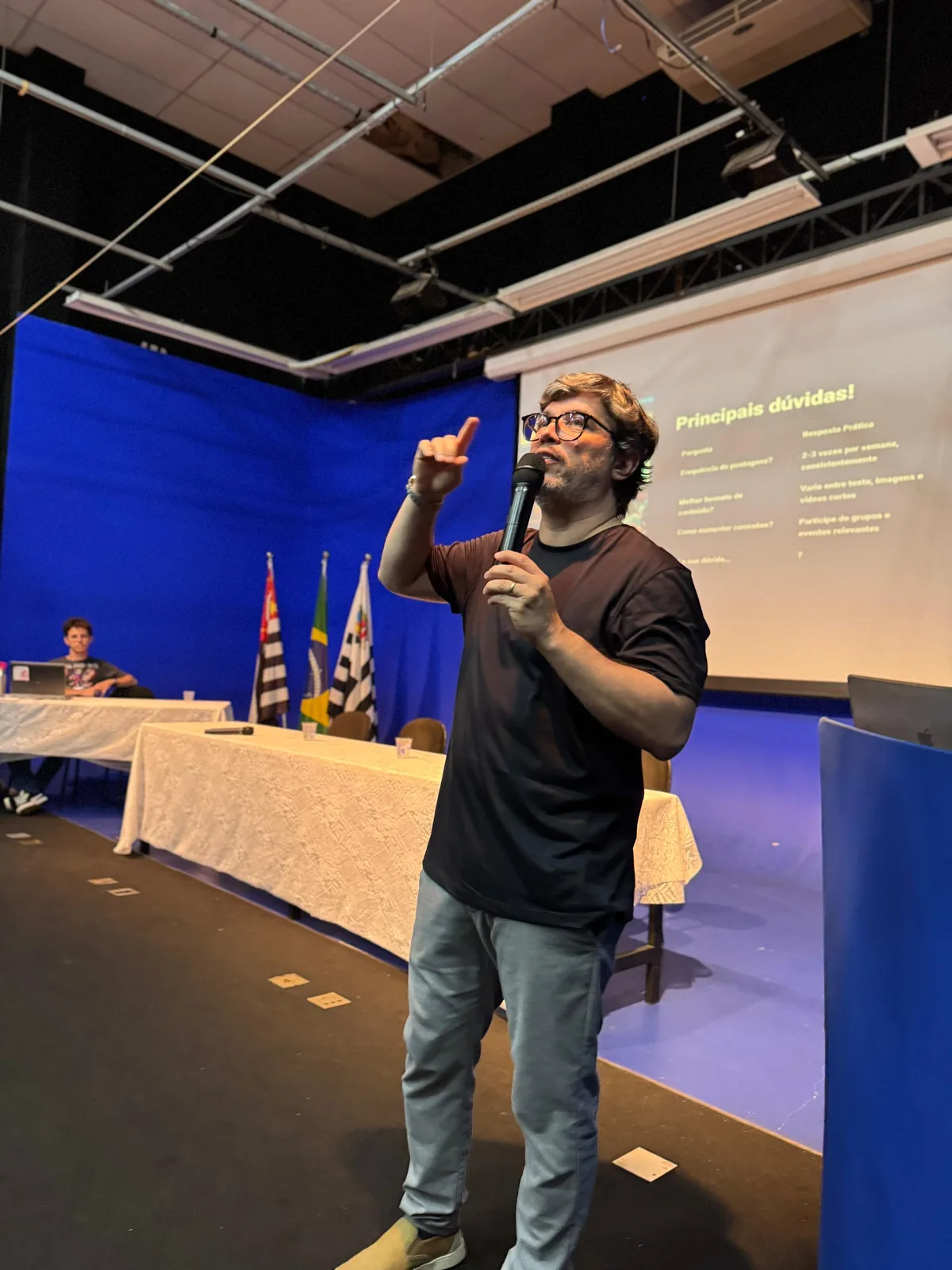 Samuel Leite conduzindo treinamento de LinkedIn, no palco com microfone